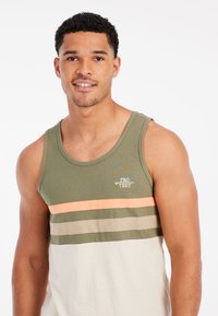 Top verde con strisce orizzontali in beige e corallo, realizzato in cotone. Presenta un colletto rotondo e il logo "PRO TEST" sulla parte anteriore superiore.