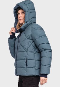 Gequiltete Steppjacke in tiefblau mit abnehmbarer Kapuze, Reißverschluss, seitlichen Taschen und elastischen Bündchen für Wärme.