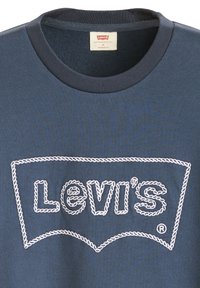 Marineblauwe t-shirt met een ronde halslijn, voorzien van een witte geborduurde Levi's logo binnen een gestikte schildvorm. Standaard pasvorm.