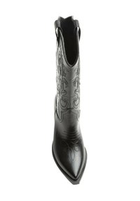 Bota de vaquero de cuero negro con punta afilada, costuras decorativas y sutiles patrones florales a lo largo del tubo. Presenta un borde superior en forma de ondulación.
