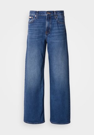 Jeans de ganga de perna larga em azul escuro, com uma cintura alta, cinco bolsos e um leve desbotamento na frente para maior textura e detalhe.