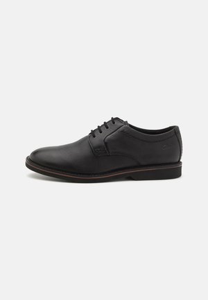 Chaussure formelle en cuir noir pour homme avec lacets, talon bas et bordure subtile marron sur la semelle, vue de côté gauche sur fond blanc.
