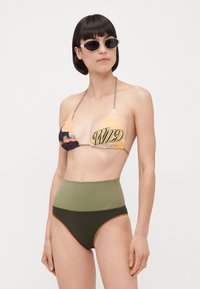 Ensemble de bikini deux pièces comportant un haut triangle imprimé avec un graphique "WILD" et un bas taille haute en vert olive et marron foncé.