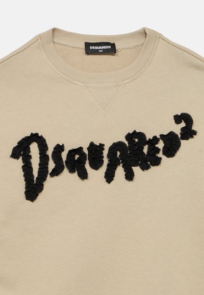 Sweat-shirt beige à col rond avec le texte noir texturé "Dsquared²" sur la poitrine et une étiquette de taille noire indiquant "14Y" à l'intérieur du col.