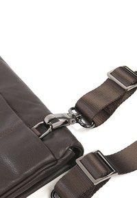 Borsa in pelle marrone con una texture liscia, dotata di una fibbia metallica e un cinturino in tessuto regolabile. Include dettagli cuciti lungo i bordi.