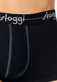 Black cotton briefs with a gray elastic waistband featuring the "sloggi" logo; visible gray stitching accents on the front.