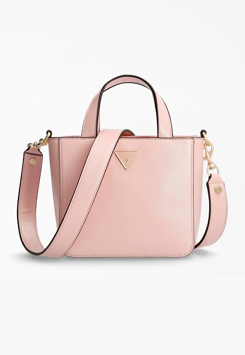 Sac à main en cuir rose avec doubles poignées et bandoulière amovible, équipé de détails métalliques dorés et d’une petite plaque triangulaire avec le logo Guess à l’avant.