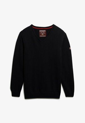 Sort strikket v-hals sweater med ribbede manchetter og nederkant. Har et mærketag i nakken og et lille accentflag på ærmet.