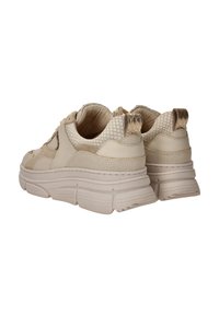 Beige sneakers met een gestructureerd mesh en glad materiaal, met een dikke zool en patroonaccenten bij de hiel en zijkanten.