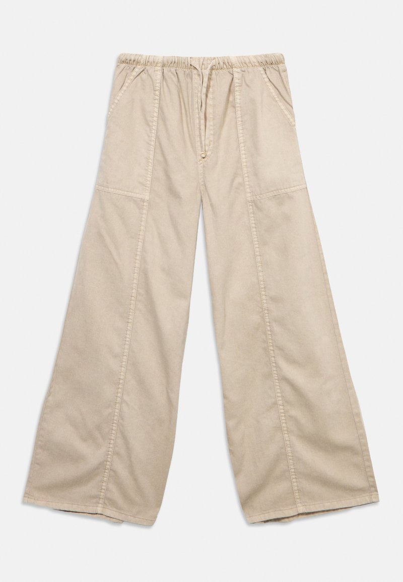 Μπεζ παντελόνι με φαρδιά γραμμή, ελαστική μέση, πλαϊνές τσέπες και εμφανείς ραφές μπροστά και στα πόδια.