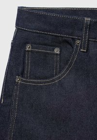 Donkerblauwe denim jeans met een klassiek vijf-pocket ontwerp, zichtbare stiksels en metalen klinknagels op de voorzak.