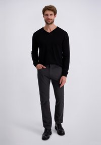 Zwarte v-hals trui, grijze textuurbroek en zwarte schoenen. Eenvoudig ontwerp, aansluitende Silhouette, gelijkmatige kleurenverdeling en minimale details.