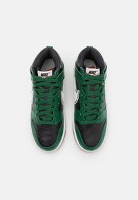 Zapatillas Nike de caña alta con puntera y talón de cuero negro, laterales de cuero verde, cordones verdes y un prominente swoosh blanco.