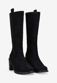 Bottes noires montantes en daim avec une finition texturée, un talon bloc et une fermeture éclair sur le côté.