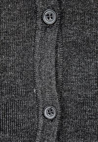 Dunkelgraue Strickjacke mit strukturierter Oberfläche, die vier schwarze Knöpfe entlang der Mitte und ein dezentes Melange-Muster aufweist.