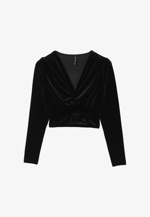 Crop top in velluto nero a maniche lunghe con scollatura a V profonda e dettaglio annodato al centro davanti.