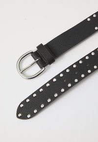 Schwarzer Leder Gürtel mit einer strukturierten Oberfläche, silberner Schnalle und Verzierungen aus kreisförmigen Metallnieten entlang seiner Länge.