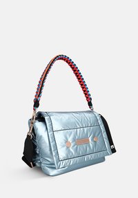 Metalen blauwe boodschappentas met een gewatteerde buitenkant, voorzien van een gevlochten handvat in meerdere kleuren en twee ronde accenten aan de voorkant.