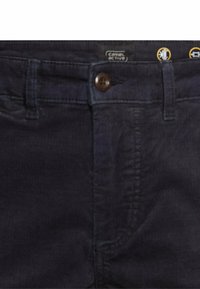 Donkerblauwe katoenen broek met knoopsluiting, subtiele gemêleerde stof en Camel Active-logo op de tailleband.