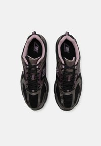 Par av svarta och lila New Balance löparskor med mesh- och syntetiska ovandelar, svarta snören och vadderade rosa kragar, visade från ovan.