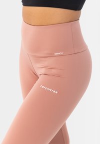 Roza visoka tajica od rastezljivog materijala. Sadrži "EnduraFlex" i "carpatree" oznake u bijeloj boji. Glatka tekstura i prilagođen dizajn.