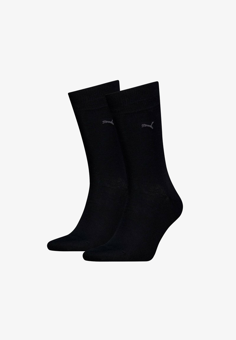 Chaussettes noires en coton avec une texture côtelée, comportant un petit logo gris. Longueur mi-mollet avec une finition lisse et sans motifs.