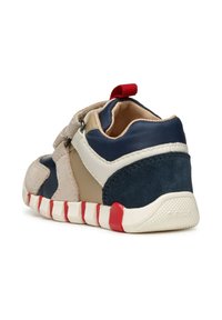Sneaker per bambini con un mix di materiali blu, beige e crema. Presenta una fibbia in velcro, un accento rosso e una suola texturizzata. Design a taglio basso.
