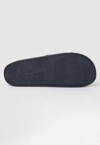 Mornarski podplat z vzorcem ribje kosti, z blagovno znamko "Pepe Jeans London". Gladka tekstura z zaobljenim robom in majhno luknjo.