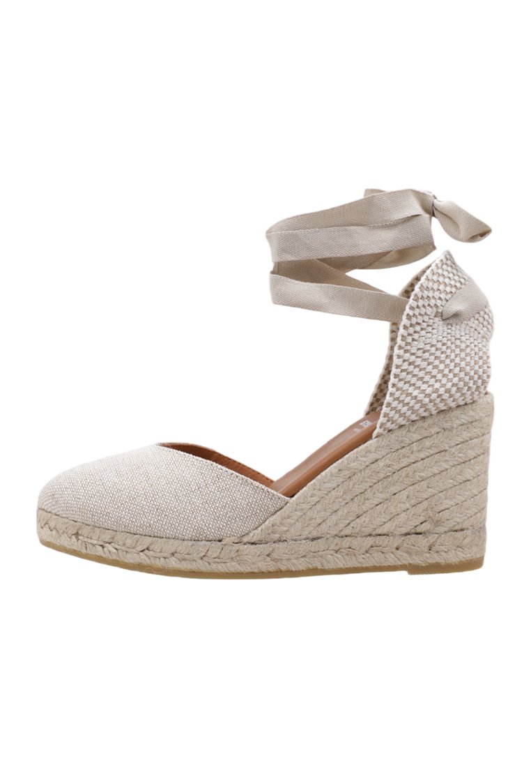 Zapato de cuña espadrille beige con parte superior de tela texturizada, suela de yute trenzada y cintas ajustables en el tobillo para un ajuste seguro.