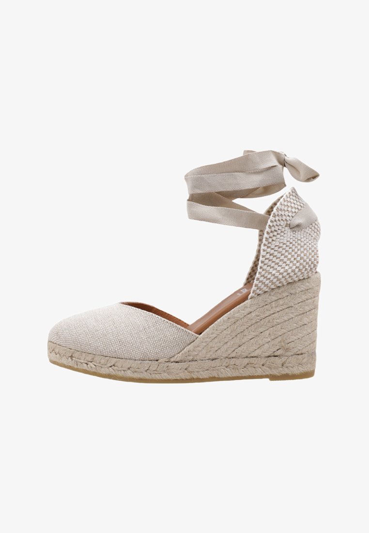 Scarpa con zeppa in espadrille beige, upper in tessuto strutturato, suola in juta intrecciata e lacci regolabili alla caviglia per una vestibilità sicura.
