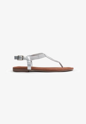 Sandal plana de tiras metálicas plateadas con un upper texturizado y una plantilla de ante marrón, que presenta una correa con hebilla para un ajuste seguro.