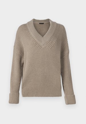 Beige pletený svetr s výstřihem do V, žebrovanou strukturou, spadlými rameny a ohrnutými manžetami. Má volný, uvolněný střih a střední tloušťku.