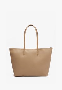 Sac cabas beige avec longues anses et fermeture éclair, design simple, texture lisse, présenté sur fond blanc.