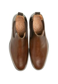 Chaussures en cuir marron avec des panneaux latéraux élastiques, bout rond et texture lisse. Présente un logo embossé sur la semelle intérieure.