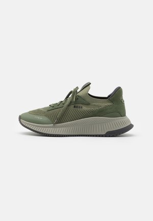 Sneaker bassa verde oliva con tomaia in maglia e suede, chiusura con lacci, suola spessa e texturizzata e marchio "BOSS" sul lato e sul tallone.