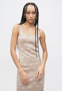 Adīts, bezroku kleita gaiši bēšā krāsā ar visu virsmu klājošu smalku ziedu rakstu, ar kvadrātveida izgriezumu un piegulošu siluetu.