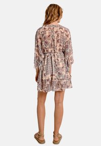 Vestito corto fluido color beige con motivi floreali, vita elastica e maniche a tre quarti. Tessuto leggero con una consistenza morbida.