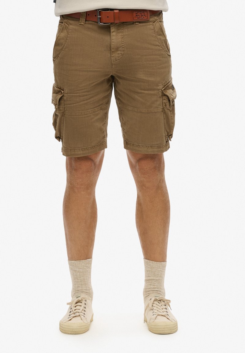 Shorts cargo beiges avec plusieurs poches latérales, fabriqués à partir d'un tissu léger. Présentent une coupe droite et un design simple et durable.