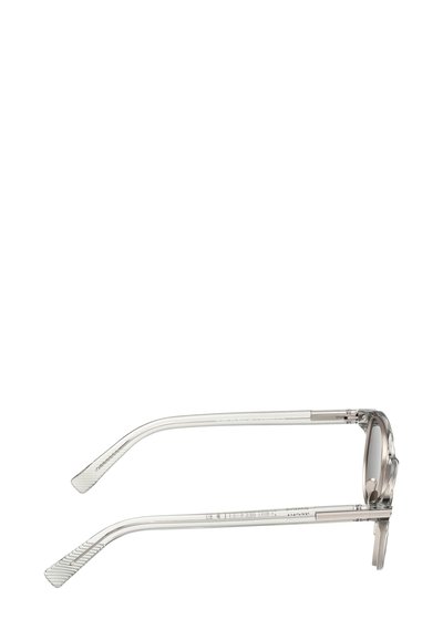 Przezroczyste okulary przeciwsłoneczne z zaokrąglonymi oprawkami, szarymi przyciemnianymi soczewkami oraz przezroczystymi, teksturowanymi zausznikami. Metalowe zawiasy zapewniają elastyczność.