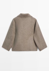 Brązowa marynarka z mieszanki wełny z kołnierzem, o luźnym kroju i rękawami do połowy przedramienia. Miękka tekstura, minimalistyczny design, bez widocznych zapięć.