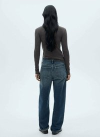 Haut marron à manches longues associé à un jean en denim bleu mi-large. Le jean présente une taille haute, des poches classiques et une coupe droite.