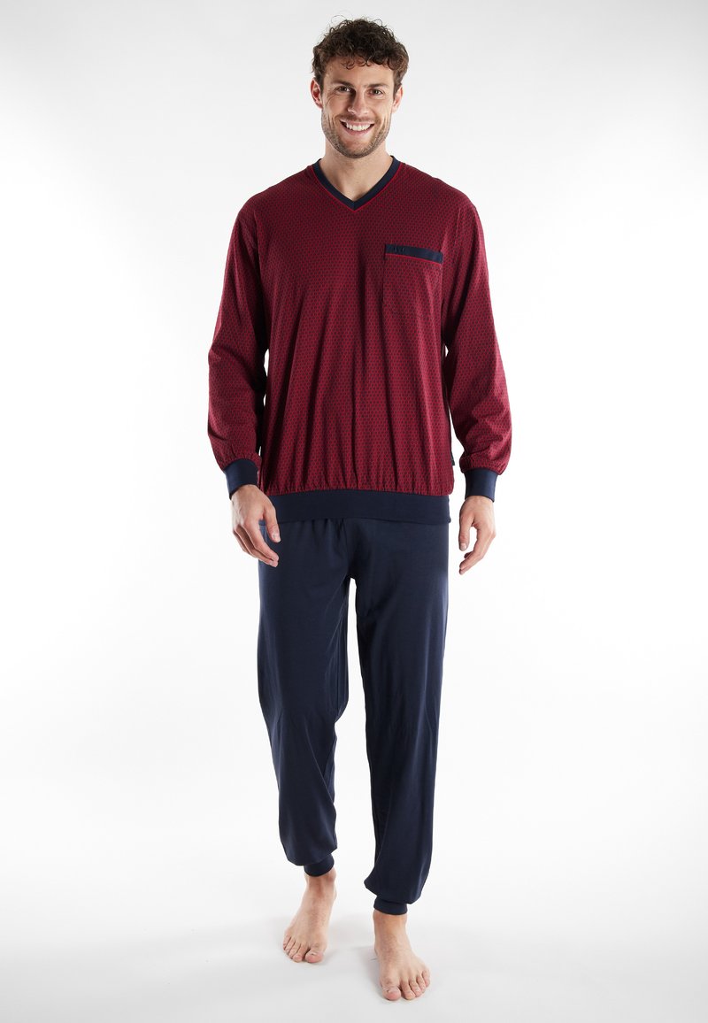 Top de manga larga con estampado rojo y detalles en azul marino, escote en V y bolsillo en el pecho. Combinado con pantalones jogger azul marino con puños elásticos.