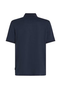 Polo à manches courtes bleu marine avec un tissu texturé, un col côtelé et un ourlet droit. Pas de logos ni de motifs visibles.