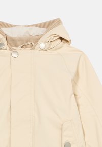 Μπεζ μπουφάν με κουκούλα, με ριμπ πλεκτό γιακά, κούμπωμα με κουμπιά μπροστά και μεταλλικά κουμπώματα snap στην κουκούλα και στο καπάκι της τσέπης.