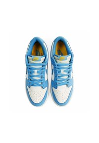 Le sneakers Nike presentano una base in pelle bianca con sovrapposizioni blu, lacci blu e un logo giallo sulla linguetta. Design della punta perforato.