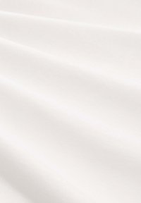 Weißer Baumwollstoff mit glatter Textur, der sanfte Falten und eine weiche Drapierung zeigt. Keine Muster oder sichtbare Hardware.