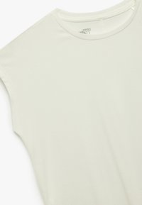 Camisa blanca de manga corta hecha de suave tela de algodón. Presenta un escote redondo y una textura lisa y uniforme con detalles de costura mínimos.