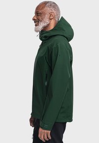 Grüne Kapuzenjacke mit strukturierter Oberfläche, ausgestattet mit Reißverschlusstaschen und verstellbaren Bündchen. Das Design hat eine lässige Passform und besteht aus strapazierfähigem Material.