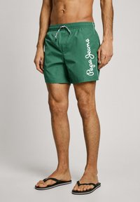 Žalios maudymosi šortai su elastingu juosmeniu, raišteliu ir baltu "Pepe Jeans" logotipu šone. Pagaminti iš lengvos, glotnios medžiagos.