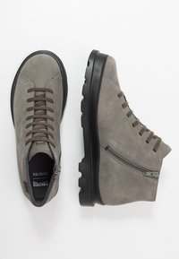 Bottines en suède gris avec un bout rond, un laçage à l'avant et une fermeture éclair. Semelle en caoutchouc avec un dessin texturé pour une meilleure adhérence.